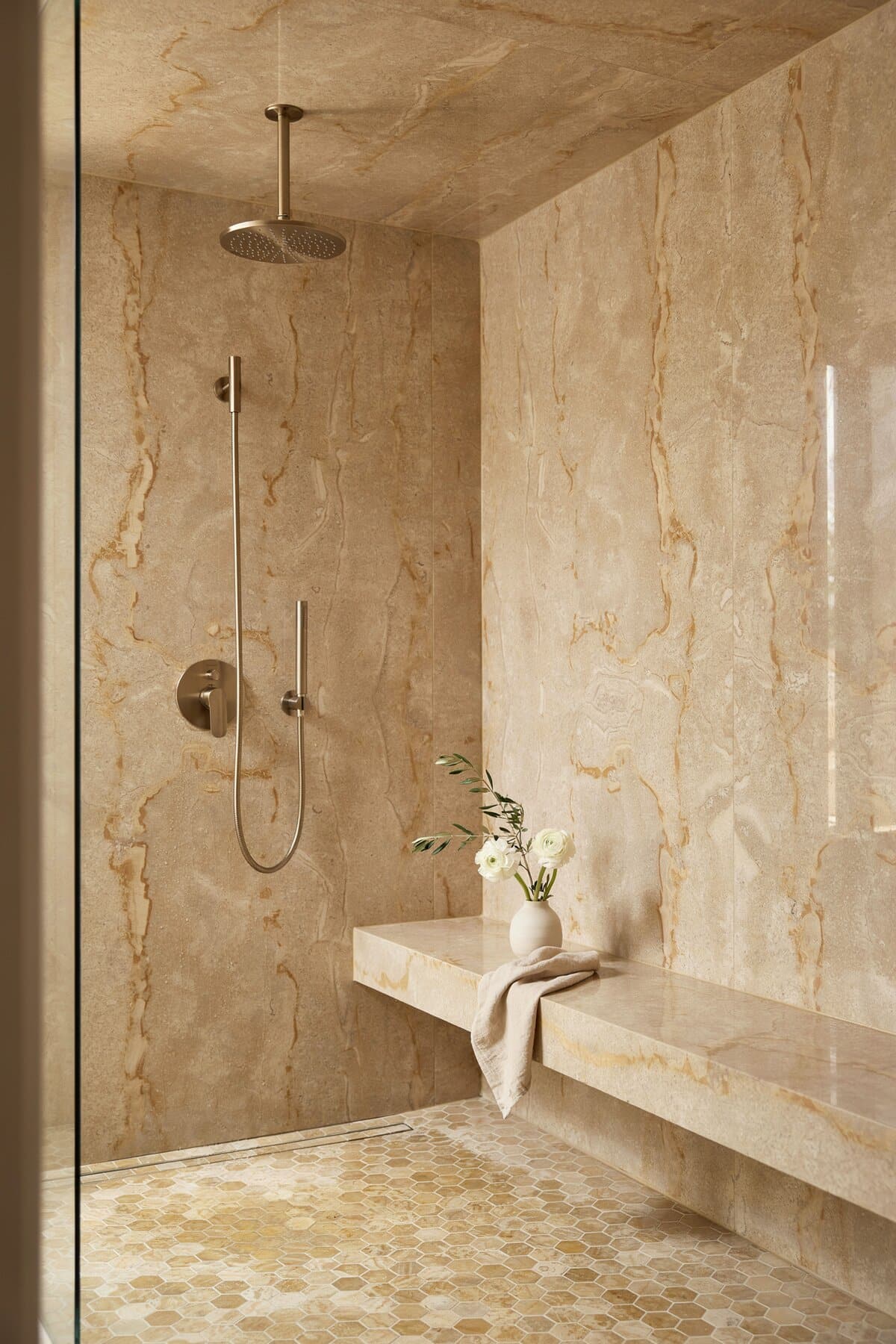 Bathroom with gold and yellow scheme, flower vase and built-in bench