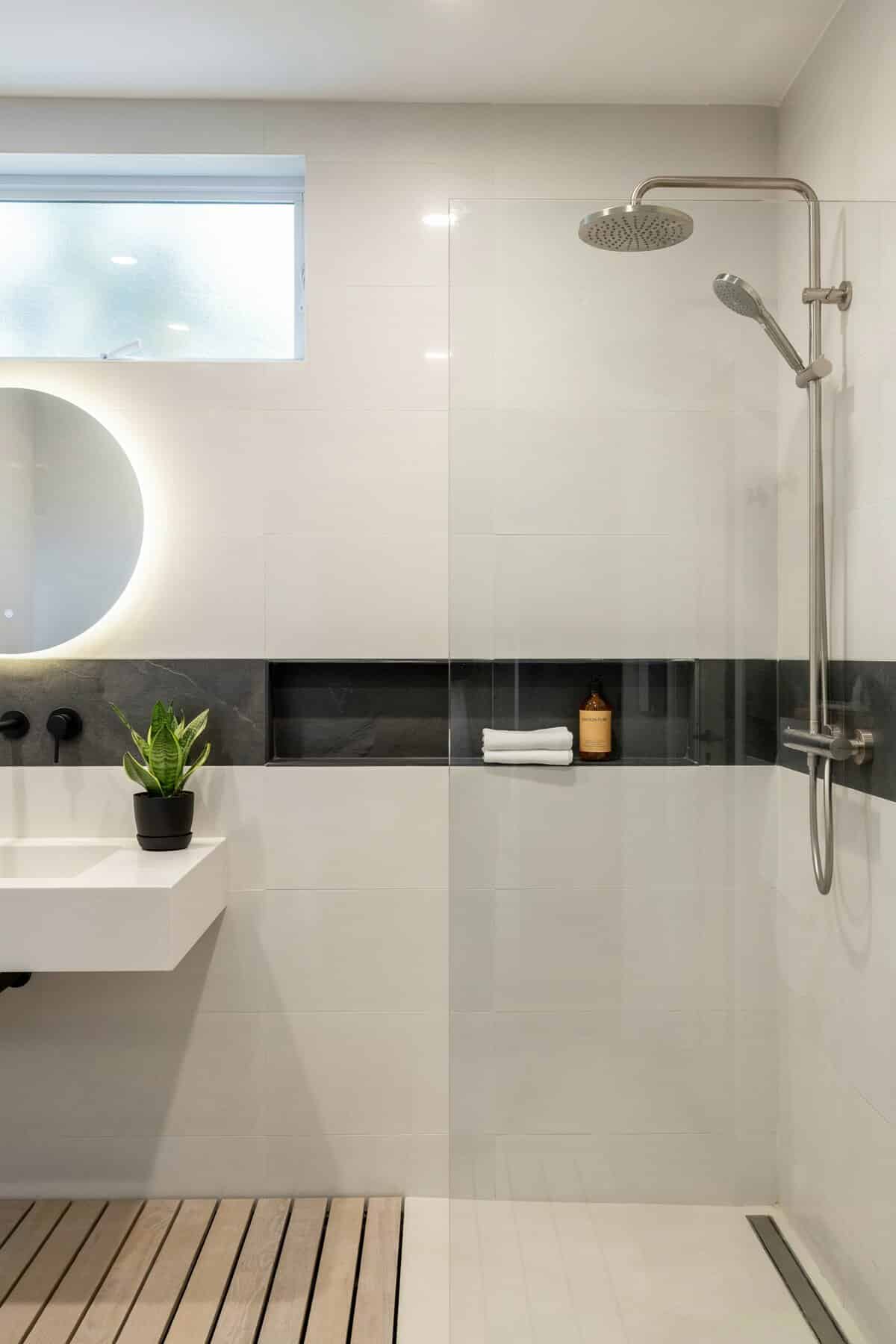 Bathroom with offwhite tiles with black stone accent strip