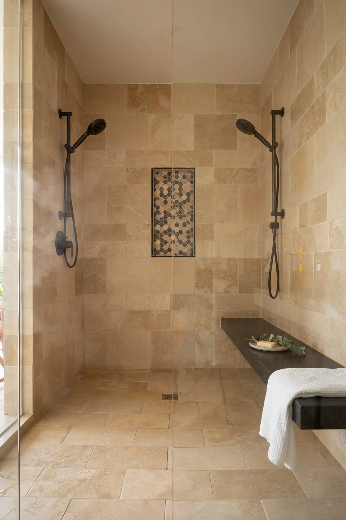 Bathroom with two telephone showers, black bench, accent wall