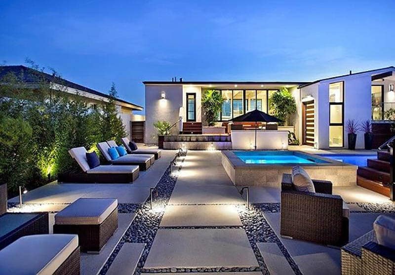 Modern backyard with gravel and concrete patio with pool and spa