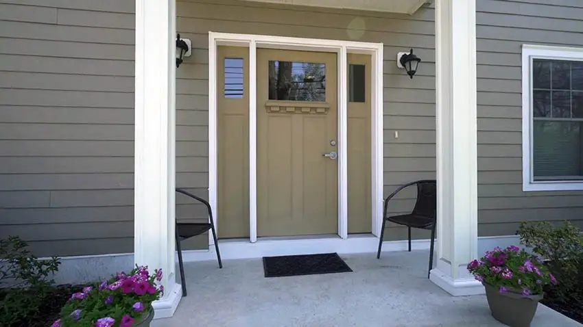 Beige door with black garden chairs and welcome mat