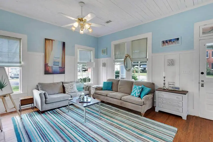 Blue and white living room with wainscoting and area rug