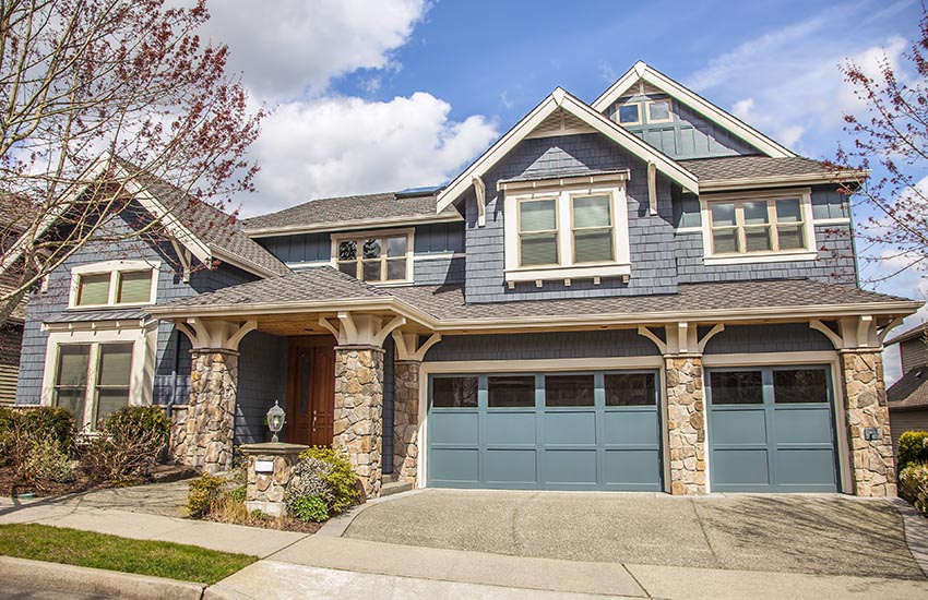 Bright blue garage doors on bluish grey house