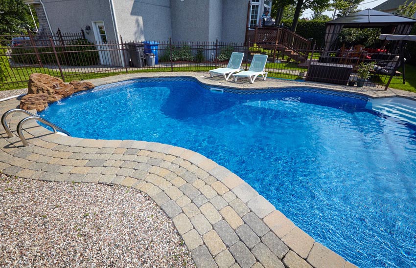 Blue kidney pool with paver border