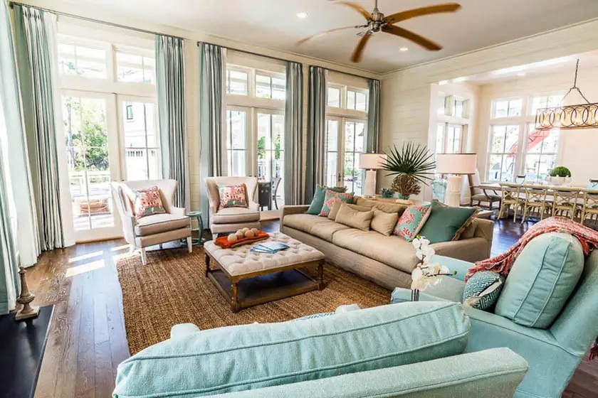 Coastal living room with wood flooring, jute rug and high windows