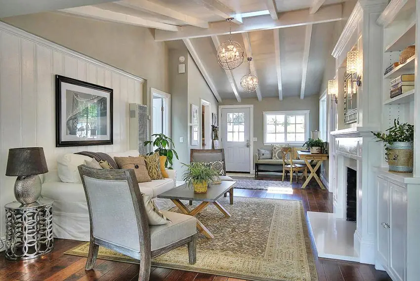 Cottage style living room with vaulted ceiling, white shiplap walls, area rug and fireplace