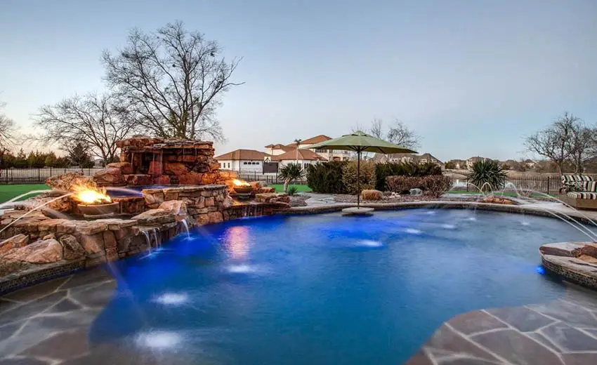 Custom stone swimming pool with elevated hot tub, water jets, waterfalls and two fire bowls