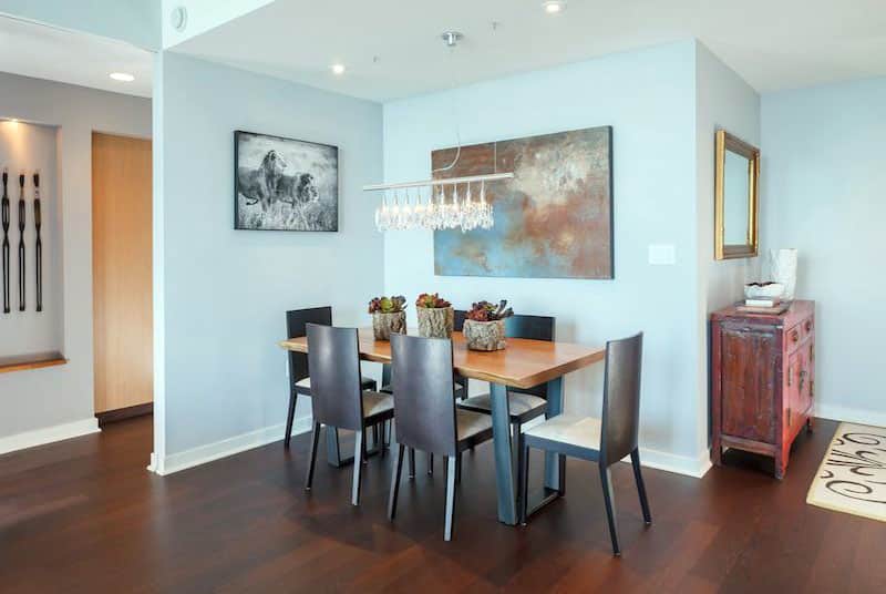 Dining room with modern linear chandelier and wood flooring