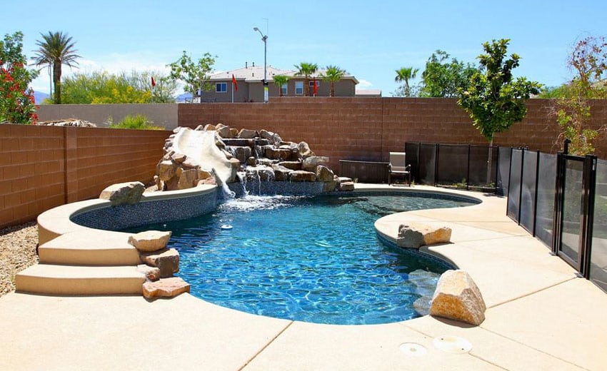 Kidney shaped pool with water feature rock waterfall and slide