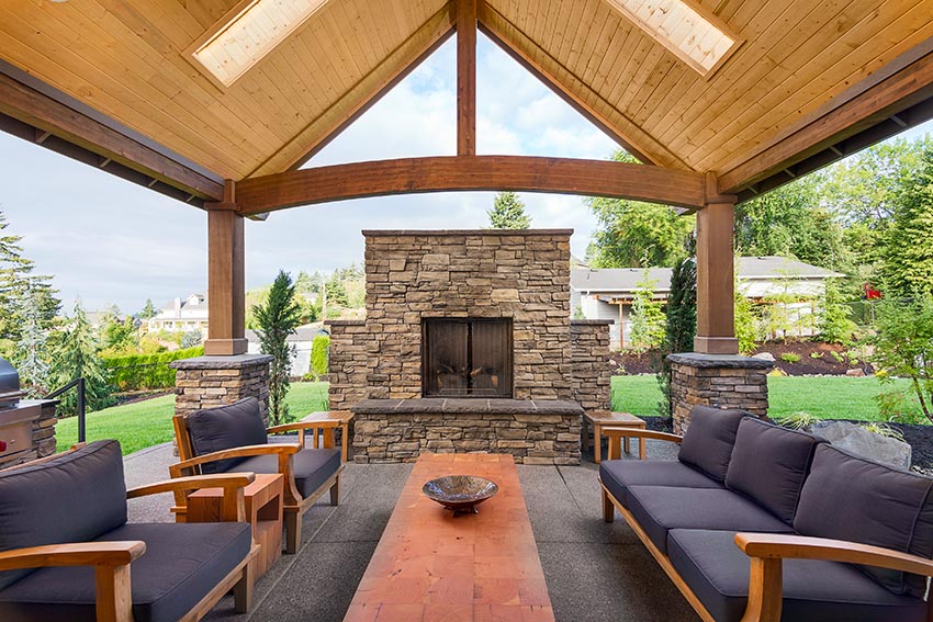 Large luxury backyard pavilion with chairs and outdoor fireplace