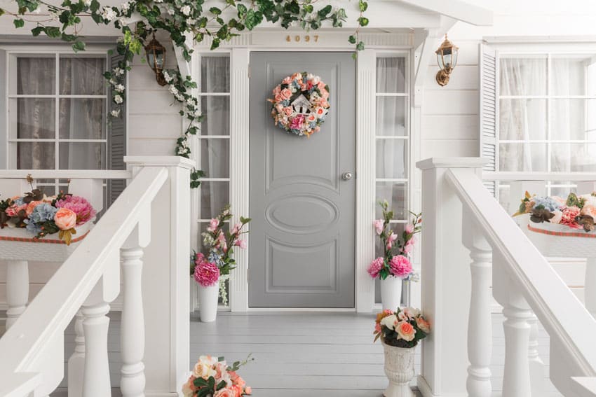 Light gray front door on home with floral decorations
