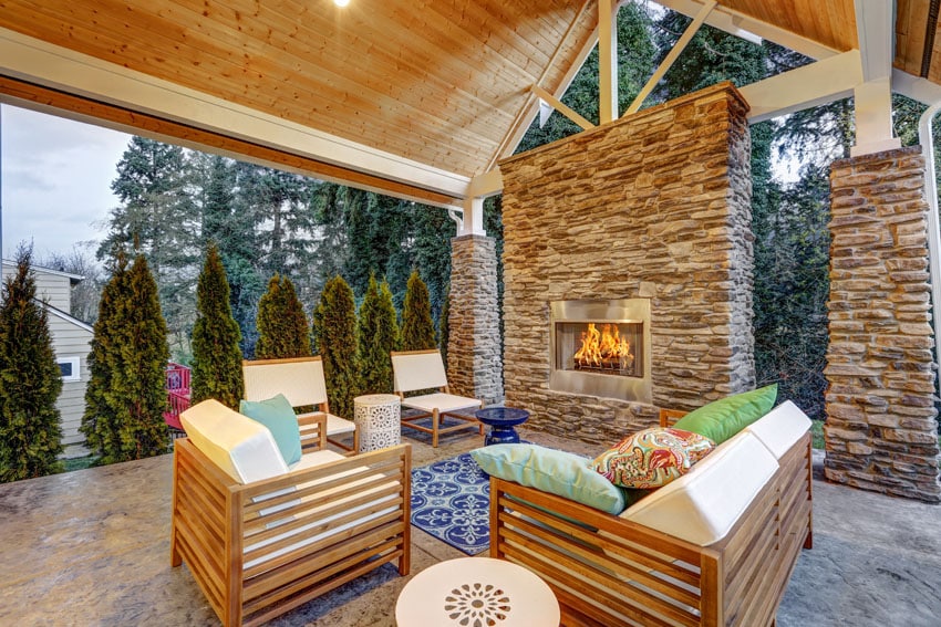 Patio with vaulted ceiling, blue area rug and column with stone cladding
