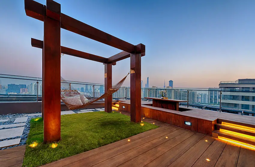 Rooftop patio with wood structure with hammock and grass lawn