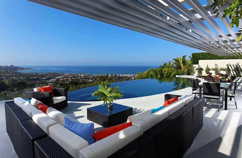 Modern swimming pool patio with pergola and ocean views