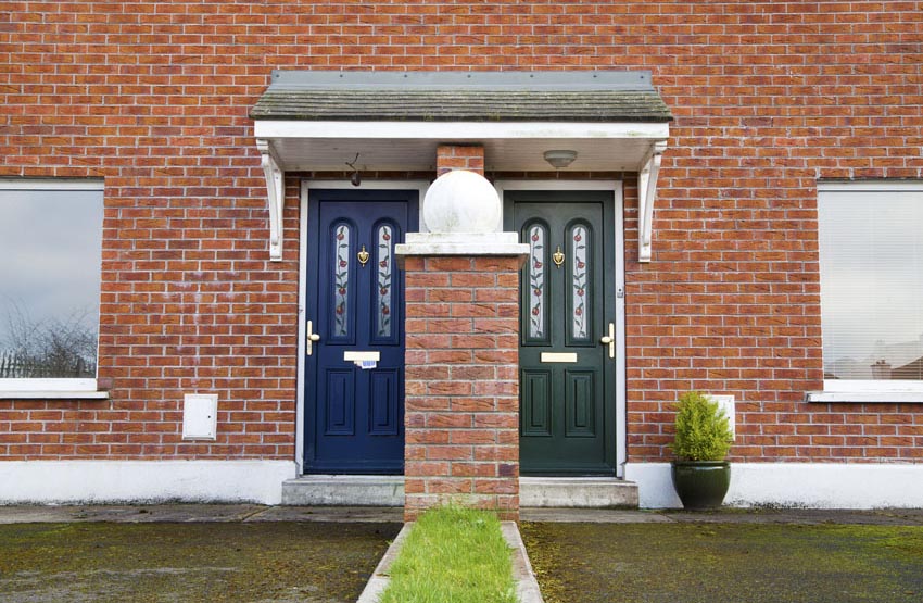 Navy and green front doors on duplex brick house