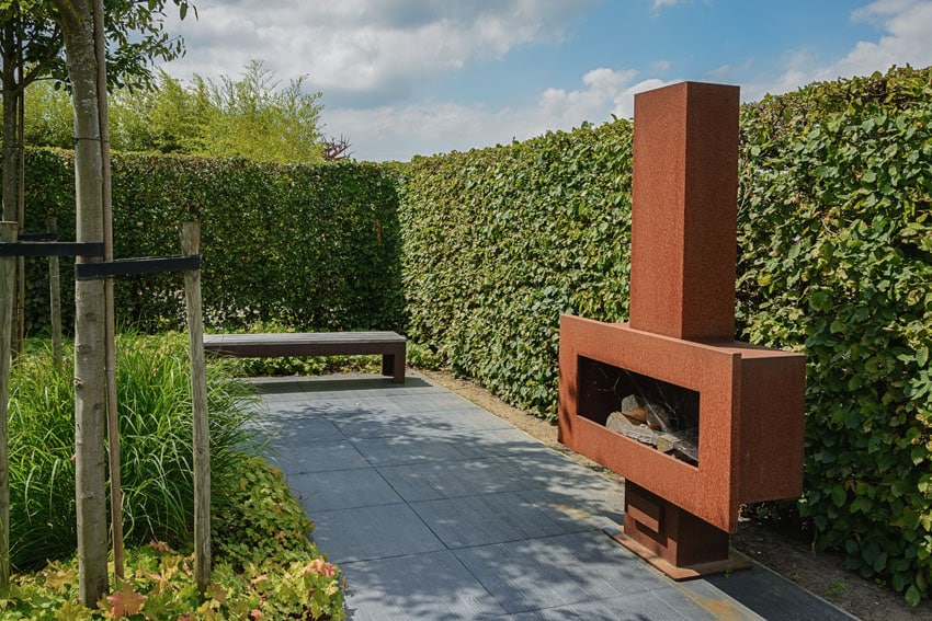 Patio with hedge walls and modern fireplace