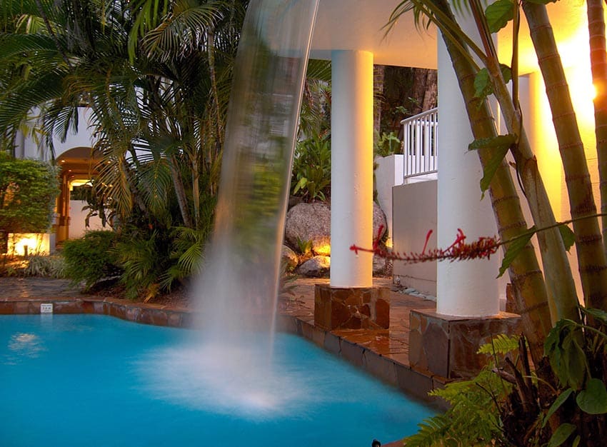 Pool waterfall feature with tropical landscaping