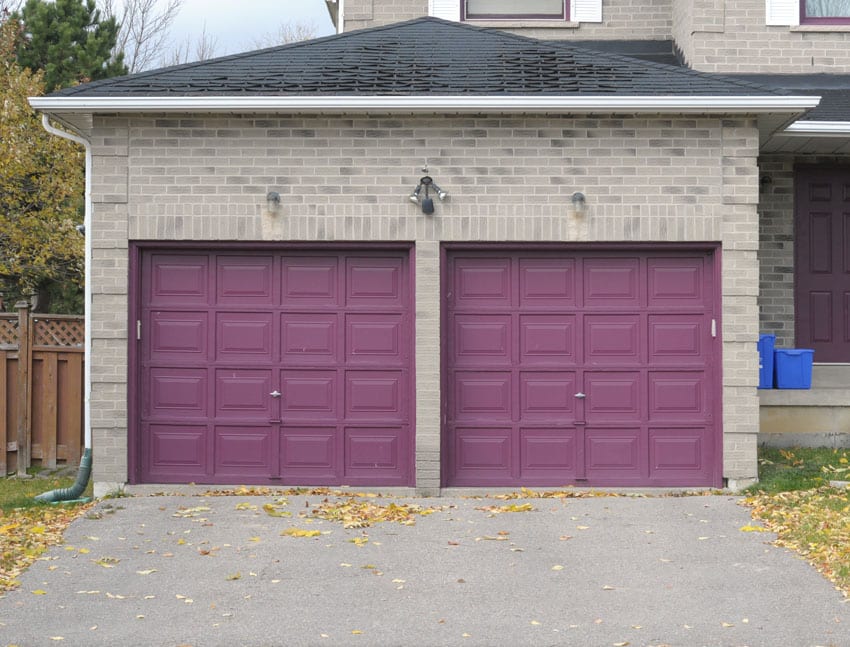 Eggplant colored door matched with gray brick facade