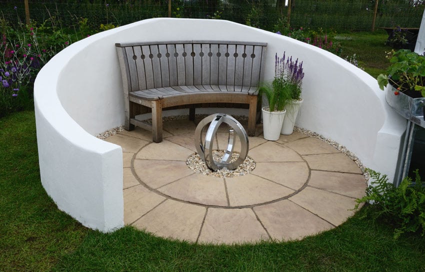 Semi-circle patio with wall wood bench and metal sculpture