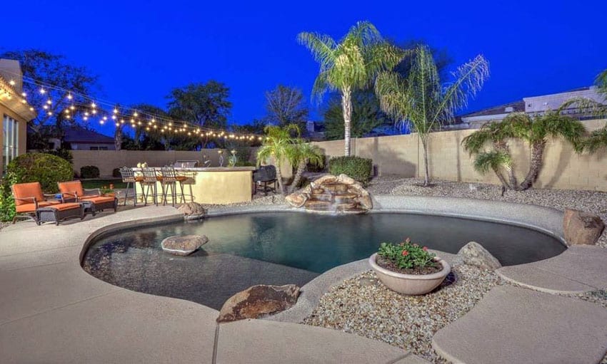 pool with beach sand entry and outdoor kitchen with bar