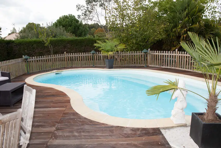 Swimming pool with wood deck and picket fence