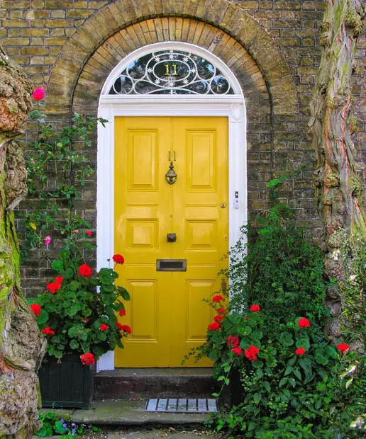 Rustic stone house with flowers and bright yellow door