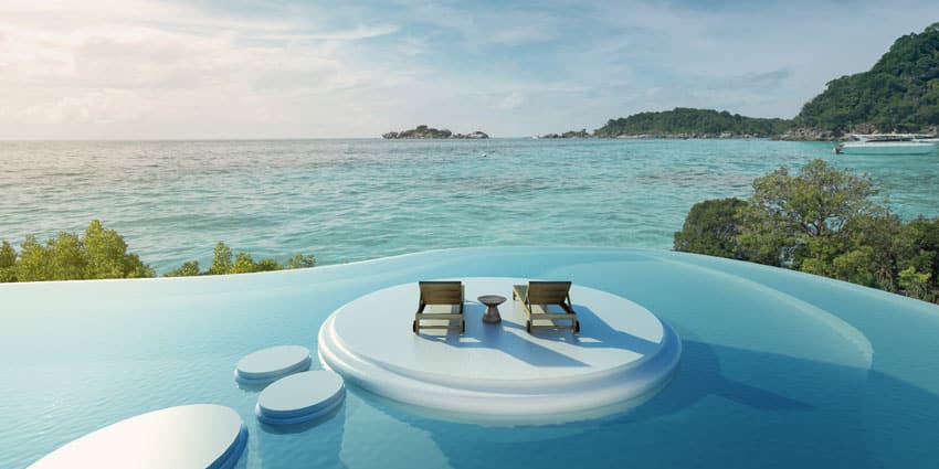 Amazing curved pool with island sitting area and ocean views