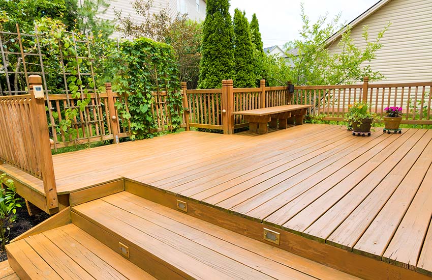 Backyard wood deck with bench railing and trellis