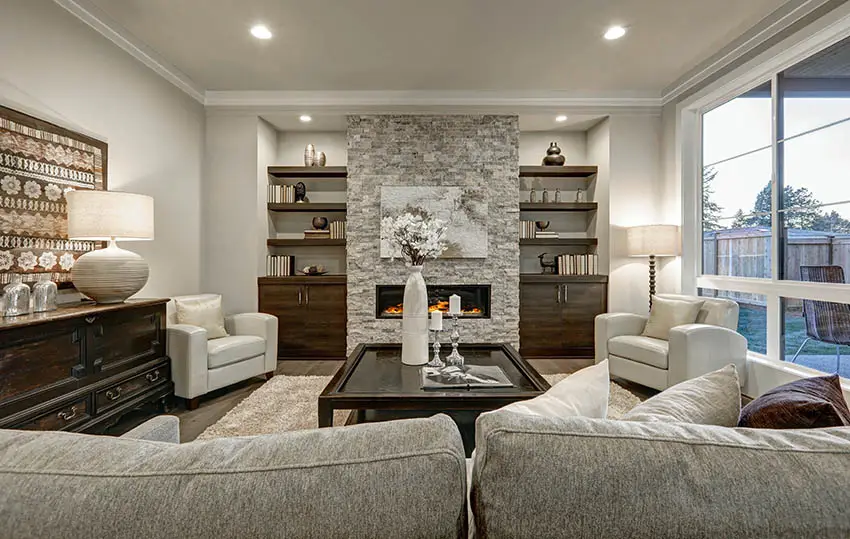 Room with stone wall accent, book shelves and grey furniture
