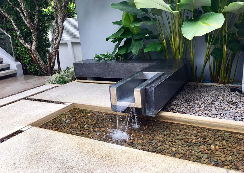 Modern patio with water feature spillway in to rock pond