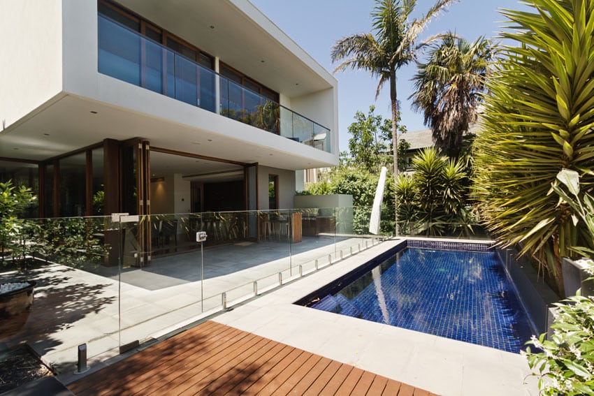 Pool with glass sliding door and tropical trees