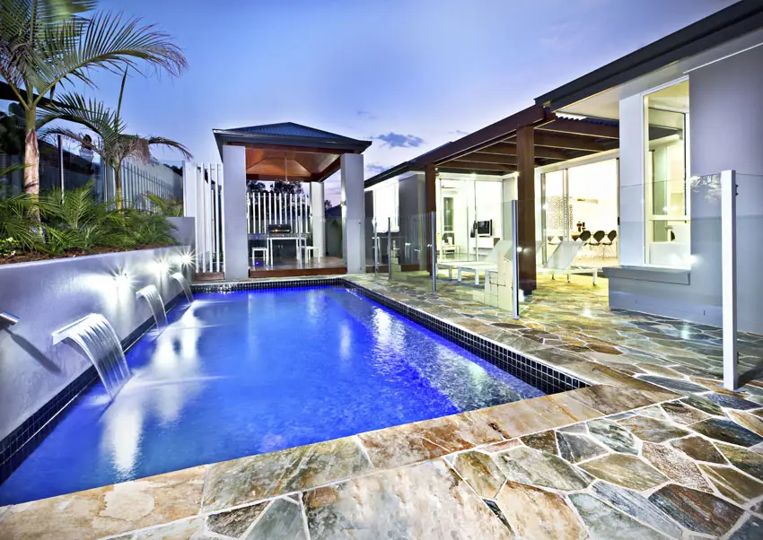 Modern swimming pool with water feature fountains and large canopy