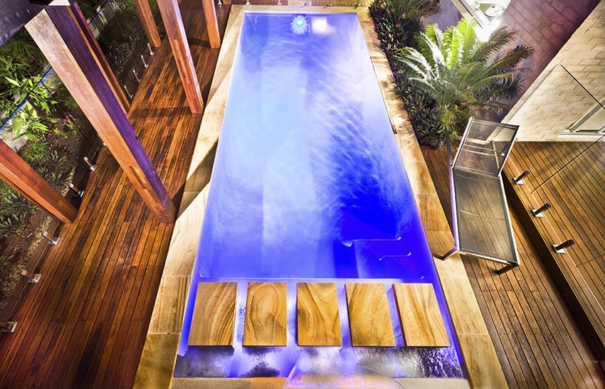 Modern swimming pool with water feature islands and wood deck