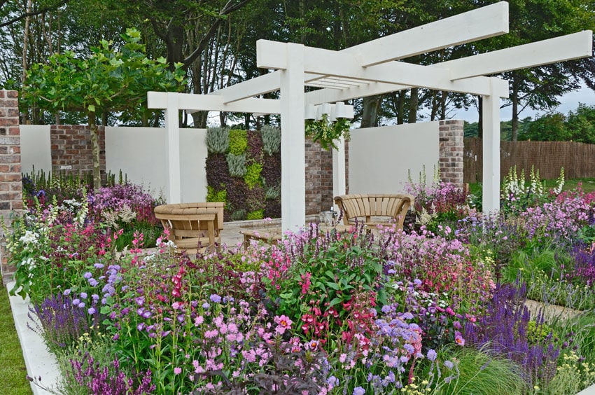 Modern white pergola in flower garden