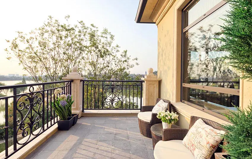 Open balcony with decorative wrought iron fence and outdoor seating