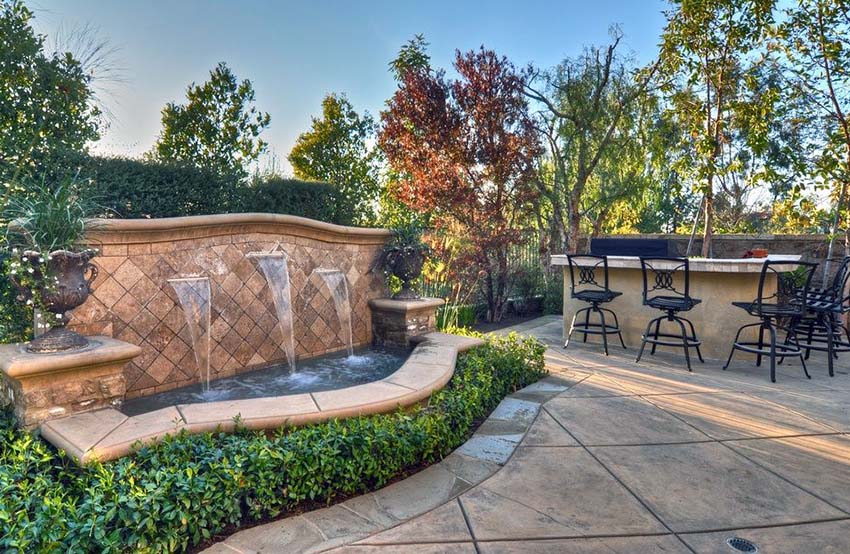 Rustic Mediterranean style water fountain in luxury backyard patio