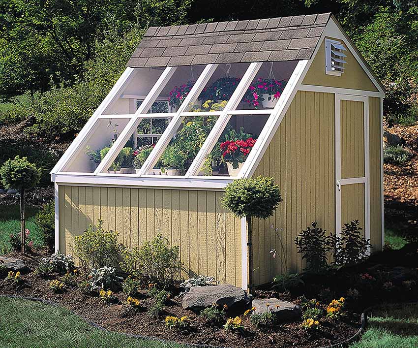 Yellow potting shed with vertical shiplap walls and potted plants