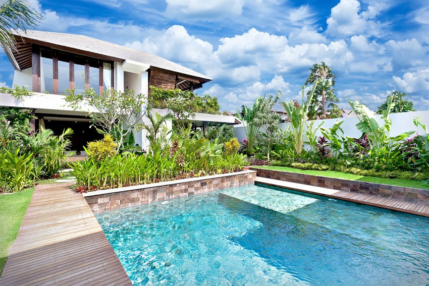 Pool with sitting platform and tropical landscaping