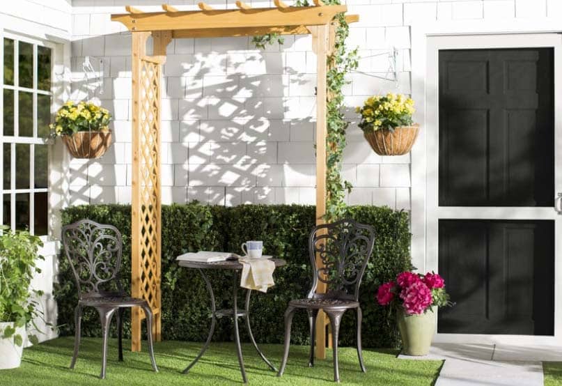 Arbor made of maple wood for backyard, hedging and black chairs