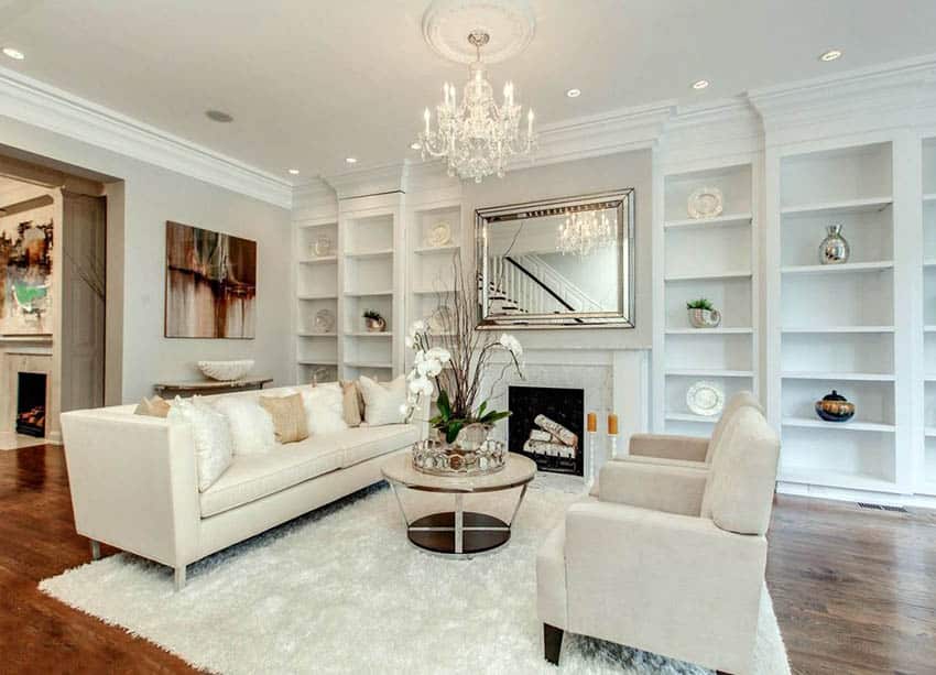 Beautiful white living room with built in bookshelves, shag carpet, wood floors and chandelier