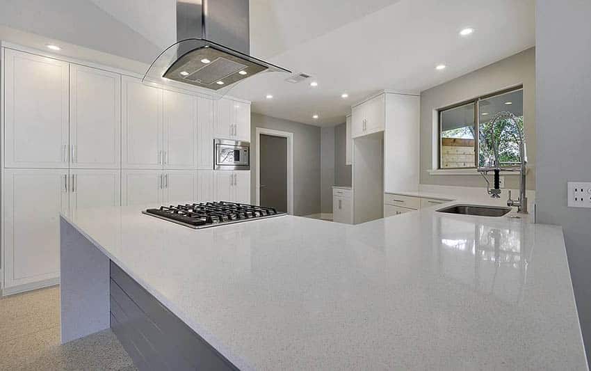 Contemporary kitchen with white cabinets and arctic white quartz counters and gray island