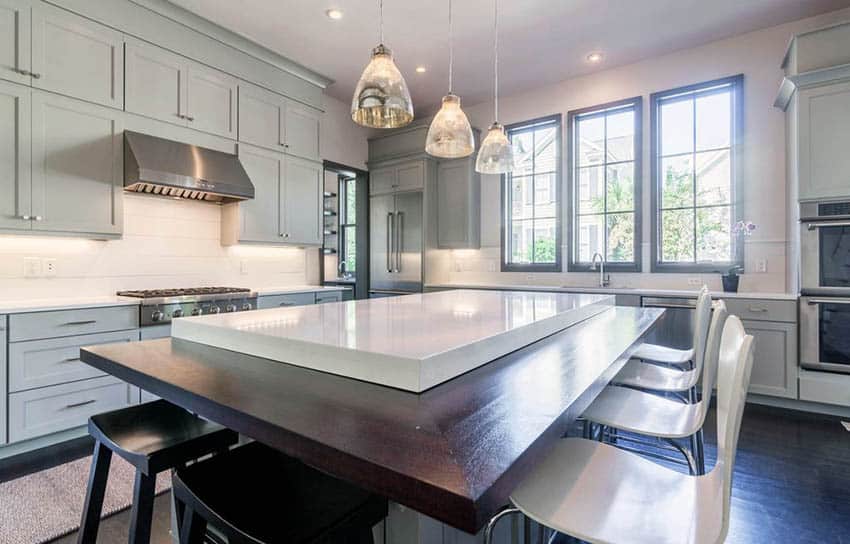 Kitchen with quartz countertops and wood breakfast bar with industrial style pendant lights