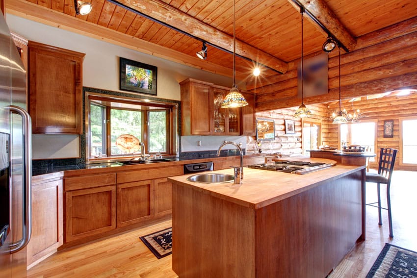 Wood beam kitchen with butcher block island and track lighting