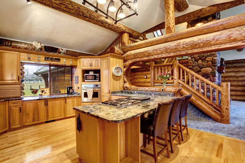 Log cabin kitchen with large beams and wood island