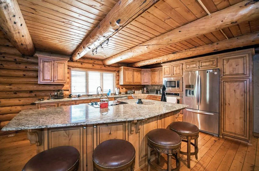 Log cabin kitchen with wood beams granite countertops and solid wood cabinets