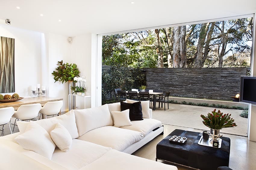 White living room with white sectional couch and outdoor living patio