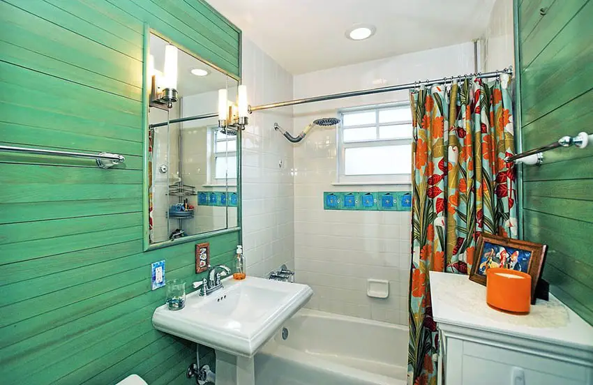 Bathroom with horizontal green plank walls and floral shower curtains