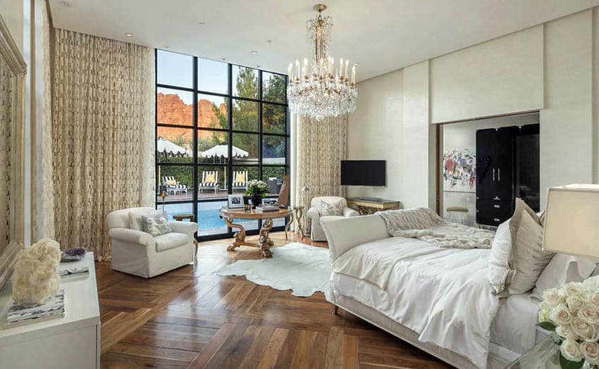 Beautiful master bedroom with teak wood flooring, sleigh bed and chandelier