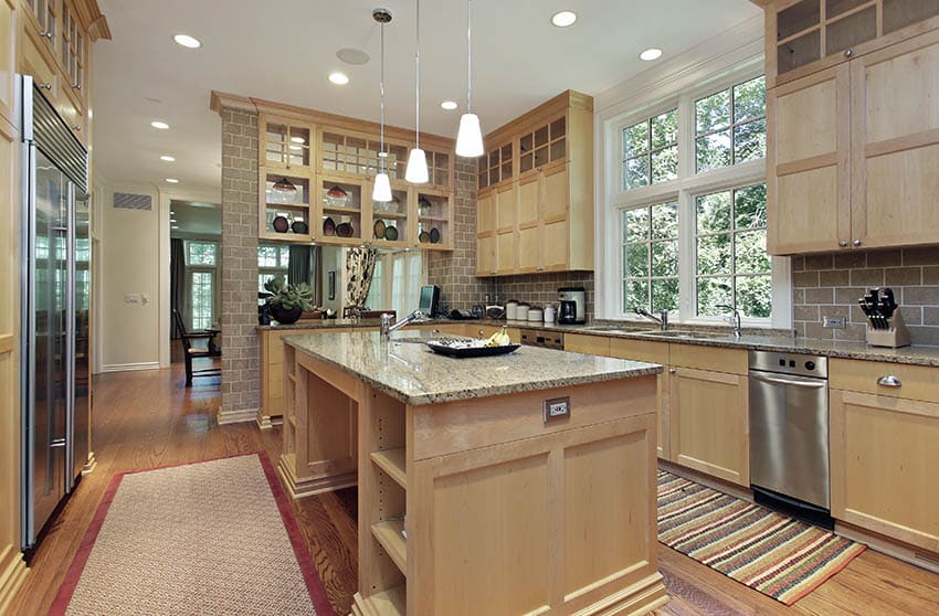 Kitchen with light wood cabinets and beige granite countertops