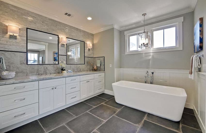 Contemporary master bathroom with black slate floor tile, pedastal tub and white vanity